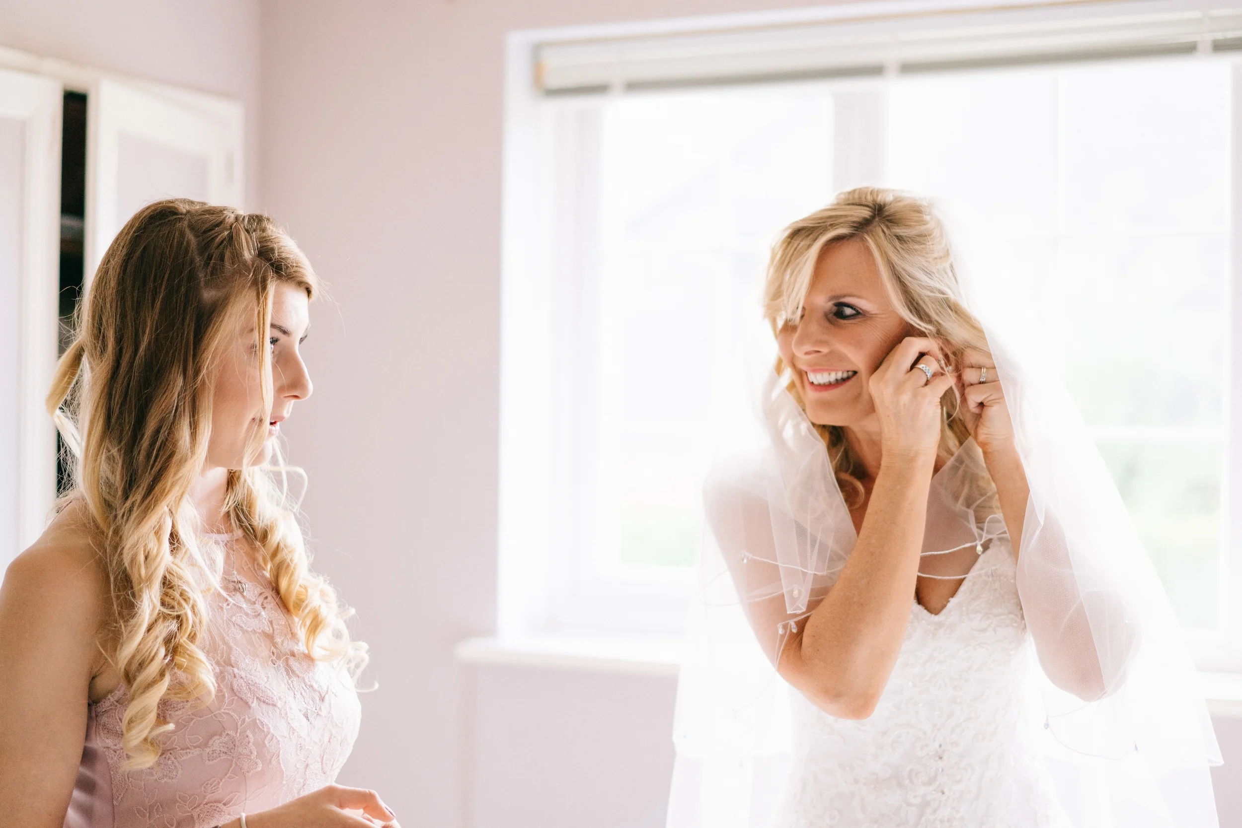 Fiona laughs with a bridesmaid while getting ready on the morning of the wedding