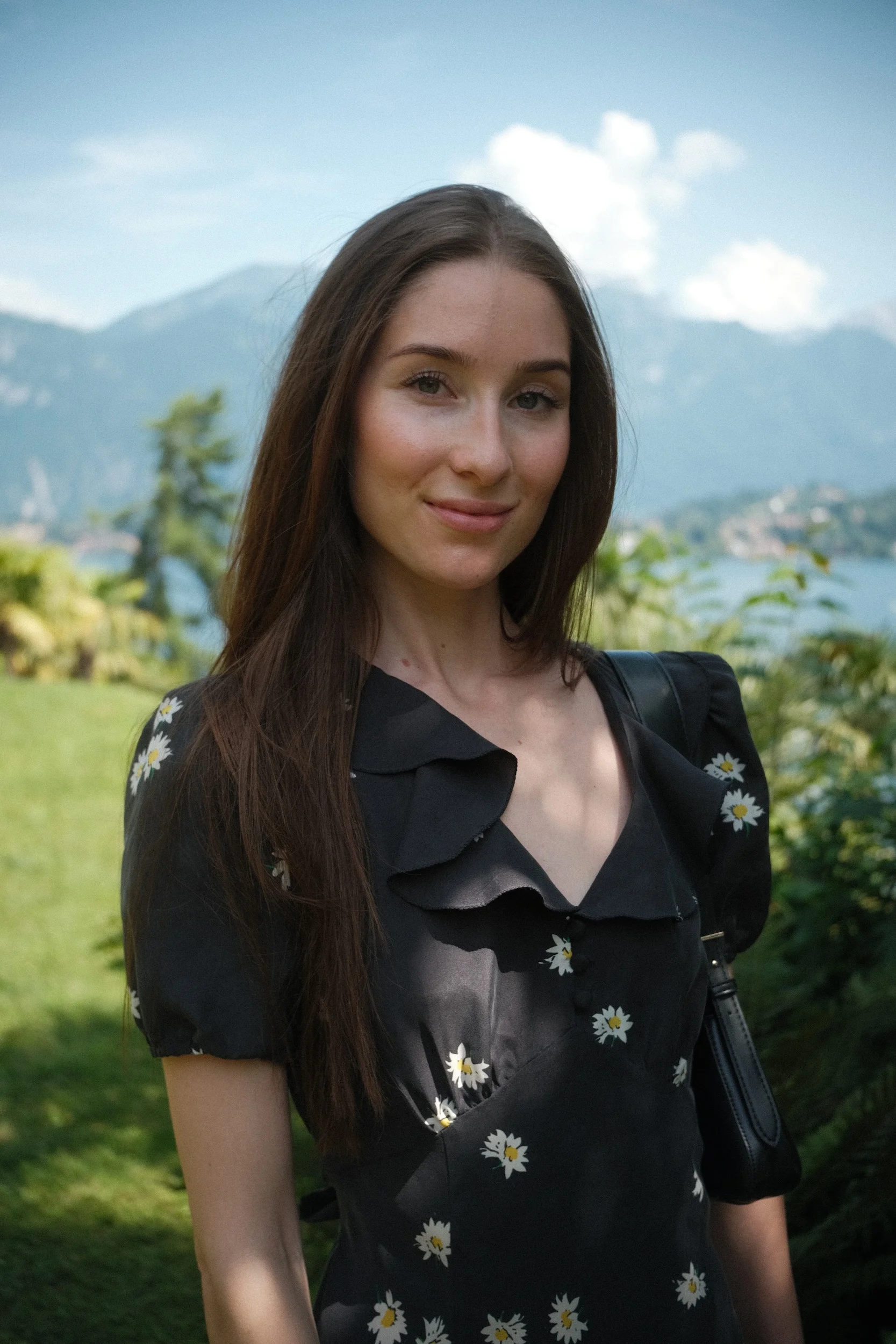 Portrait of a woman by a lake with mountains behind her